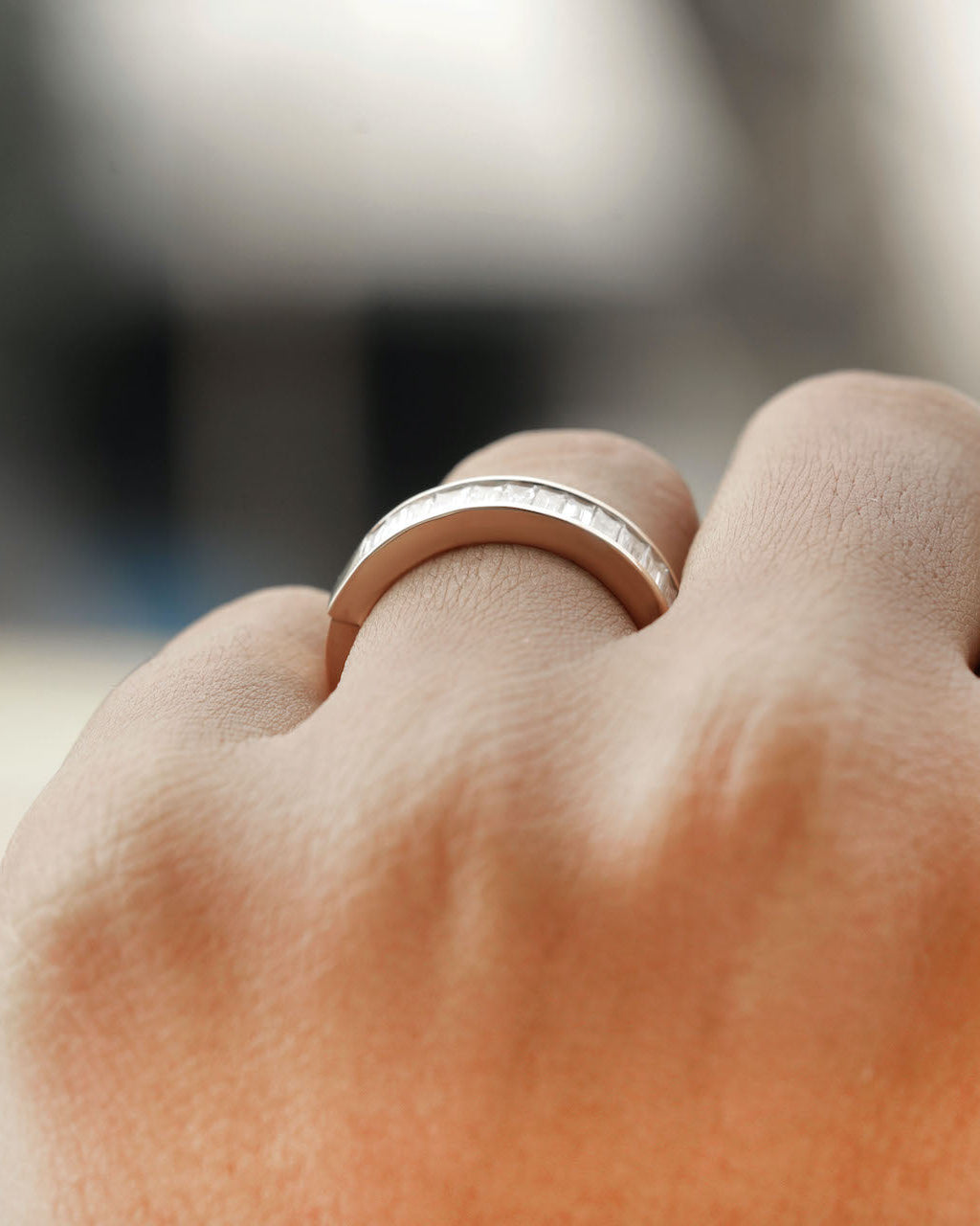 Hand wearing baguette Cut Lab diamond eternity ring in rose gold.