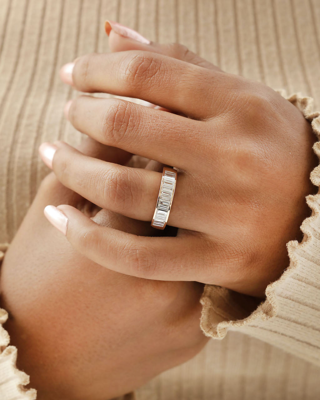 Hand wearing baguette Cut Lab diamond eternity ring in rose gold.