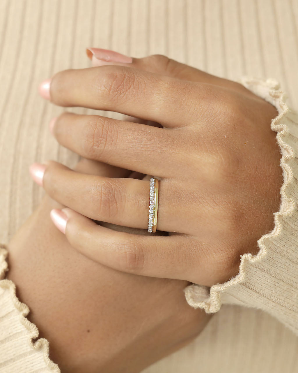 A yellow gold diamond band on a hand.