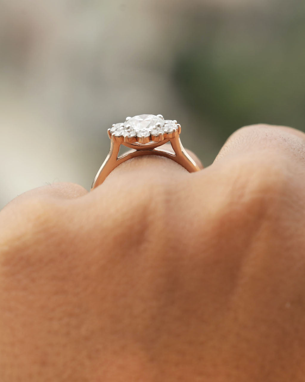 Rose gold ring with a heart-shaped diamond cluster on a blurred background.