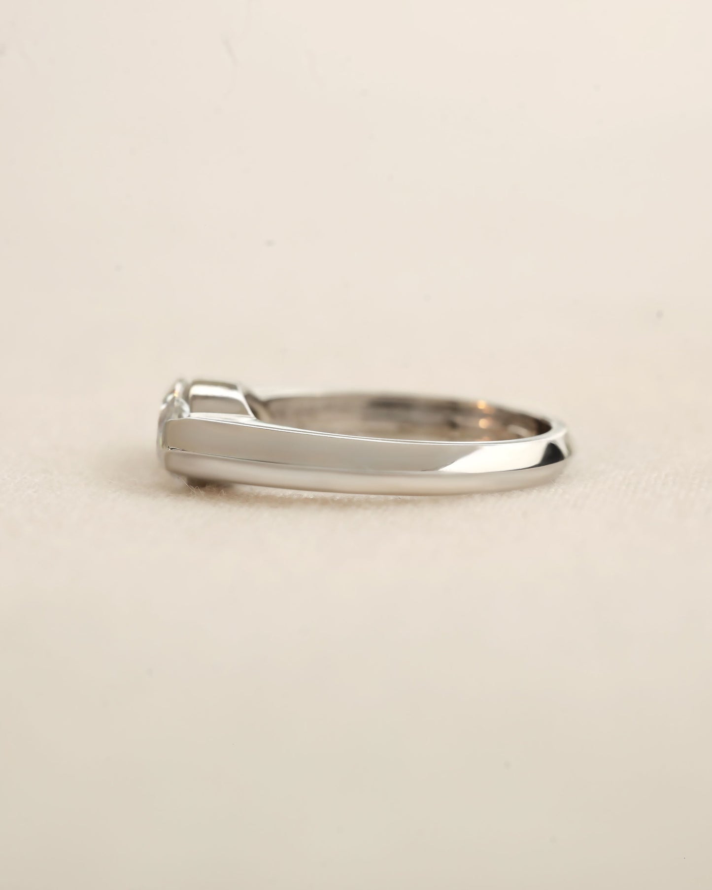 Side view of marquise cut diamond bezel ring in white gold.