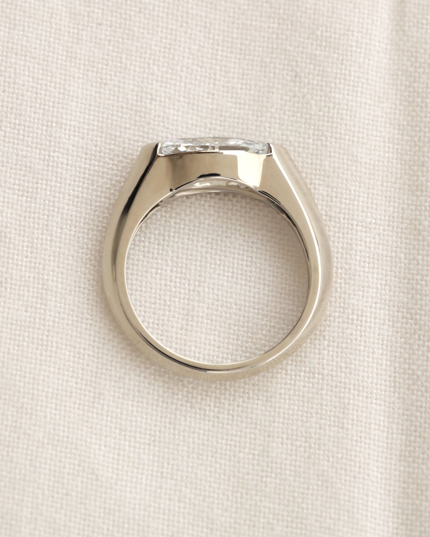 Close up shot of marquise cut diamond bezel ring in white gold.