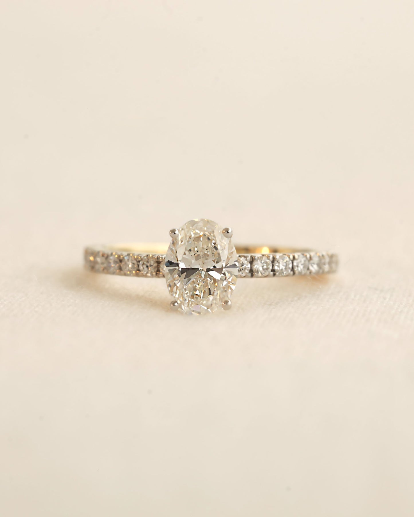 Close u shot of oval cut lab-grown diamond engagement ring in yellow gold.