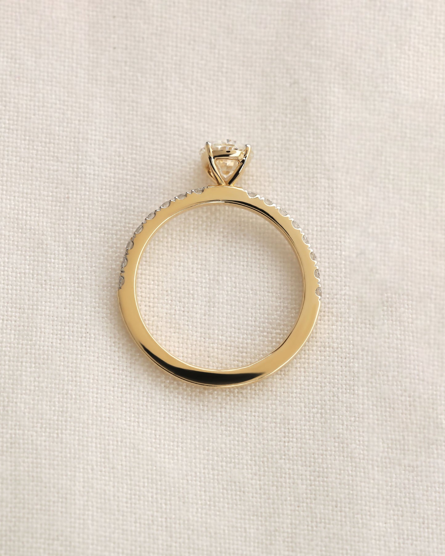 Close up shot of oval cut lab-grown diamond engagement ring in yellow gold.