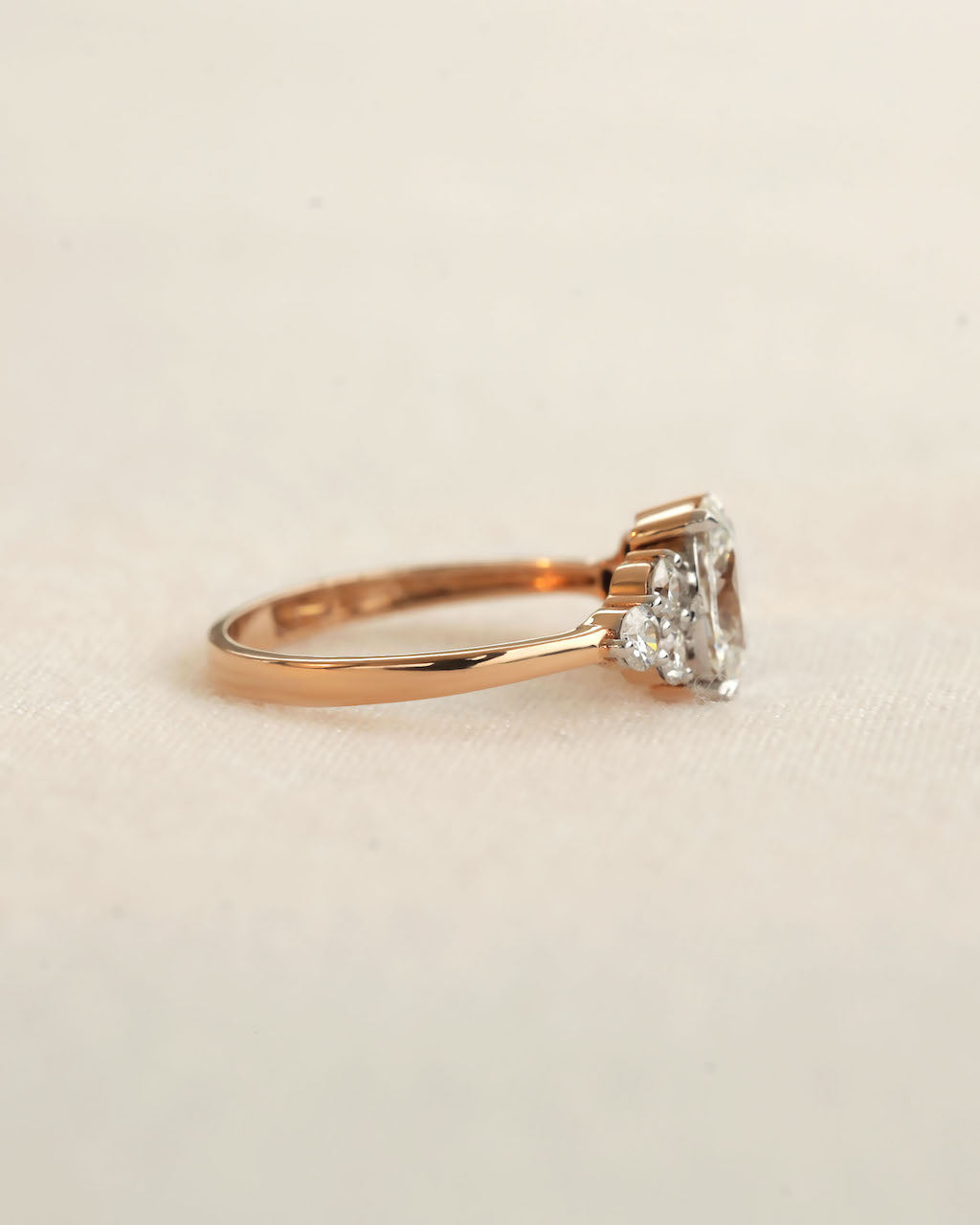 Side view of oval cut diamond engagement ring in rose gold.