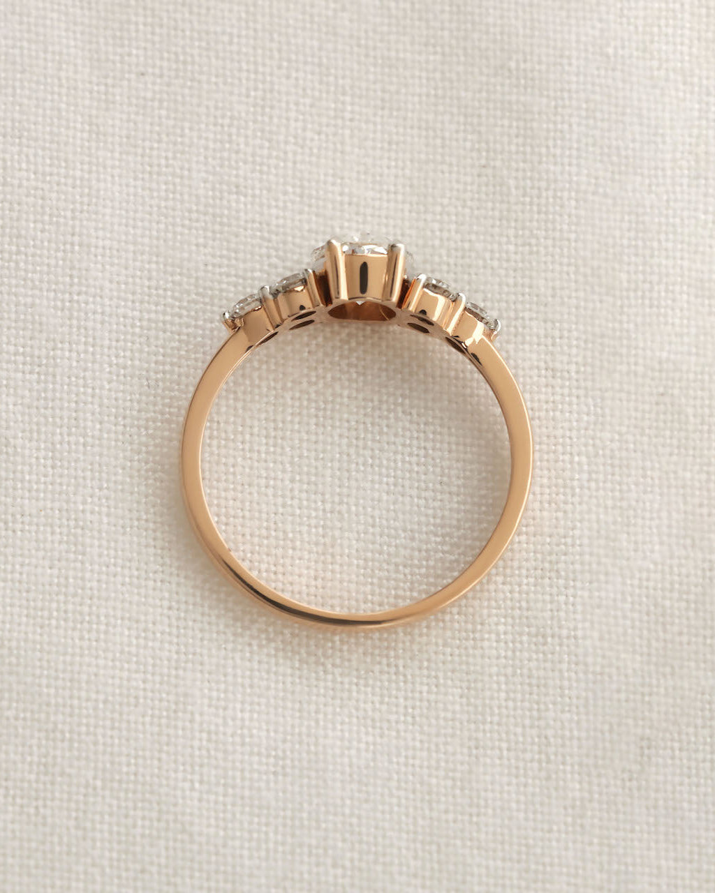 Close up shot of oval cut diamond engagement ring in rose gold.