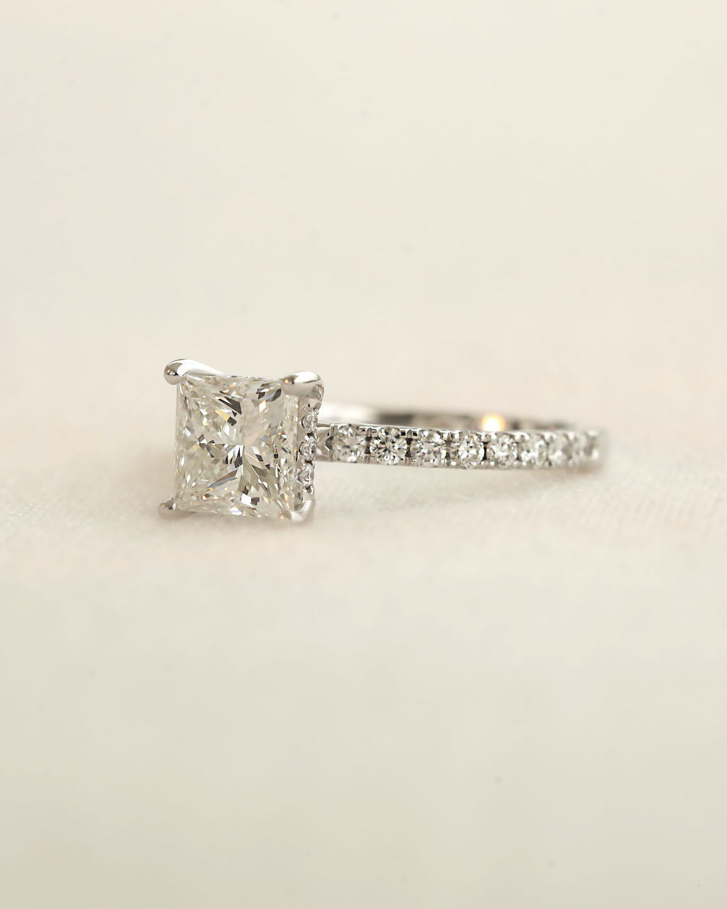 Princess cut diamond engagement ring displayed on a white background.