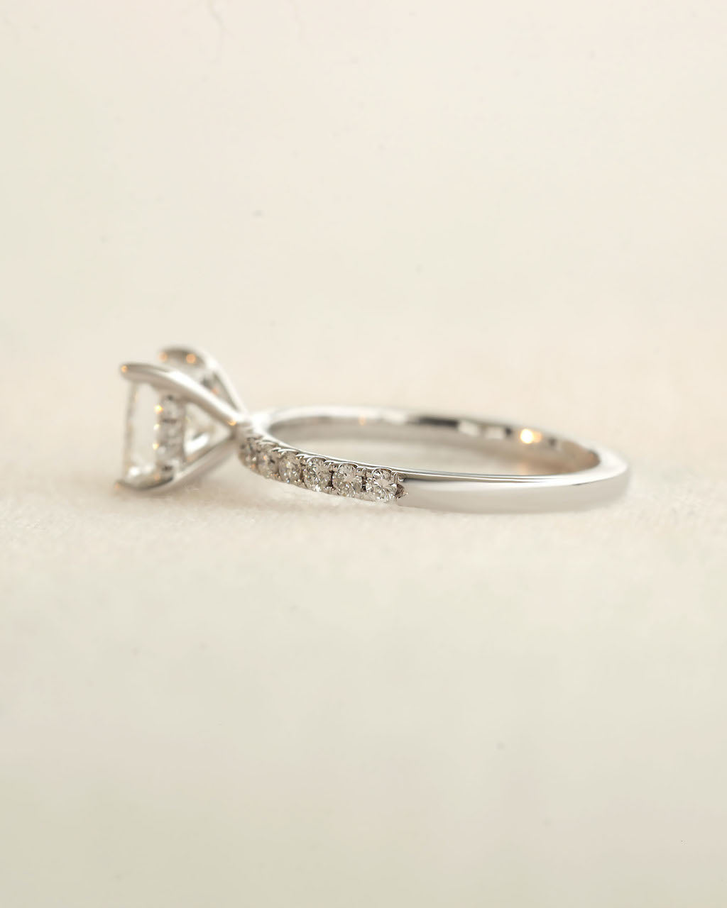 Side view of princess cut diamond engagement ring displayed on a white background.
