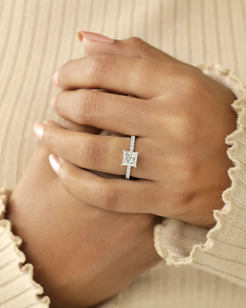 Close up shot of hand wearing a princess cut diamond ring.