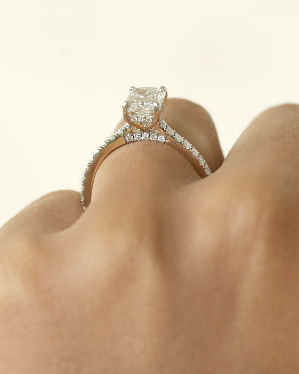 Diamond ring worn on a finger aganist a white background