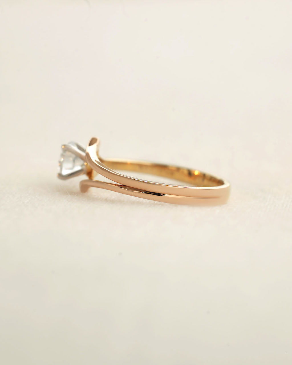 Side view of a round cut diamond ring with modern split v band .