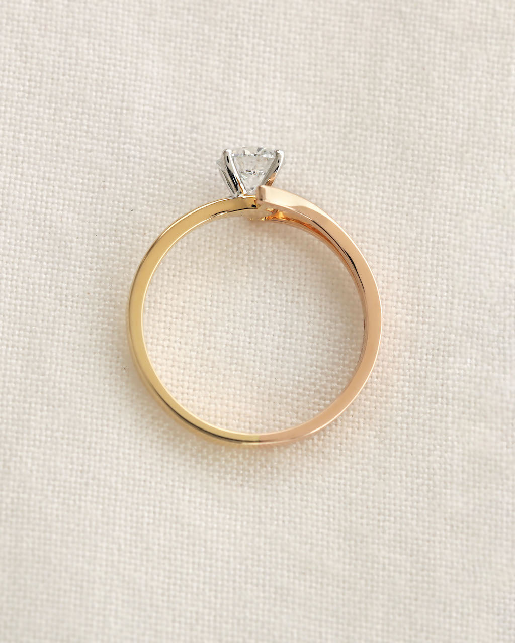 Close up of a yellow & rose gold round cut lab grown diamond ring with modern split v band.