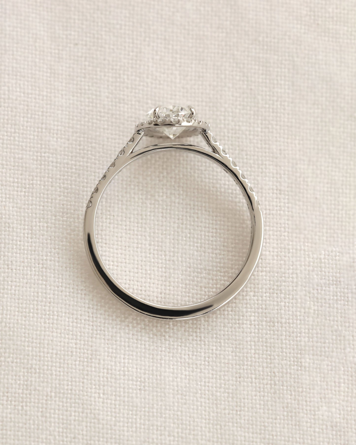 Close up shot of white gold oval halo engagement ring.