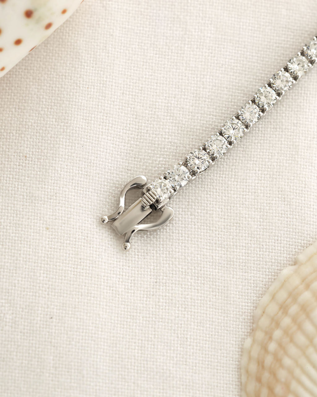 Silver bracelet with clear stones on a light fabric background