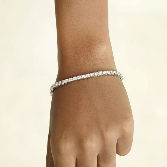 Diamond bracelet on a wrist against a beige background