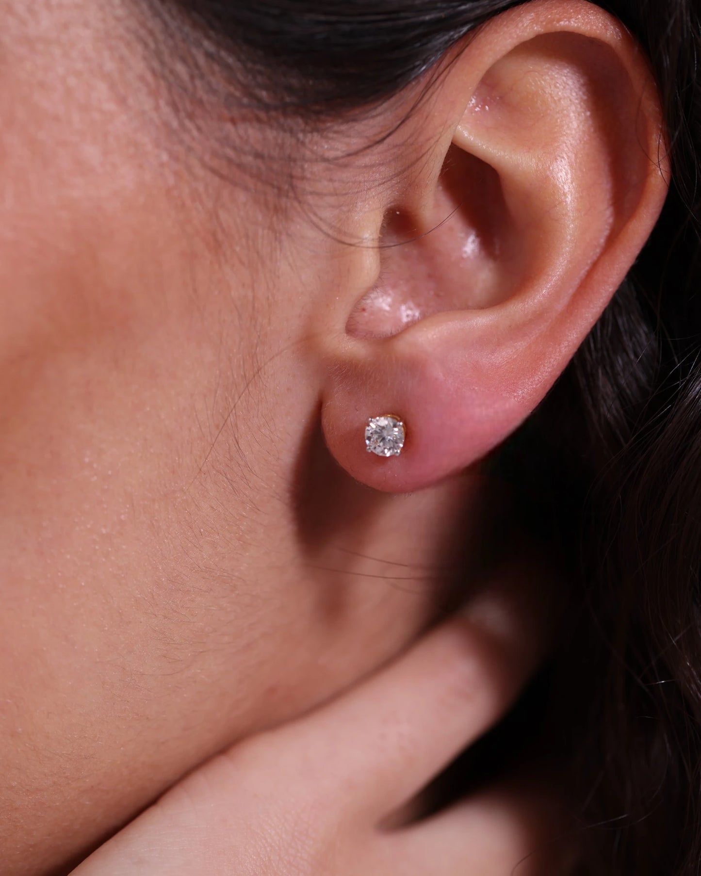 Close up of diamond studs in yellow gold.