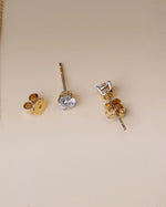 Close up of diamond studs in yellow gold.
