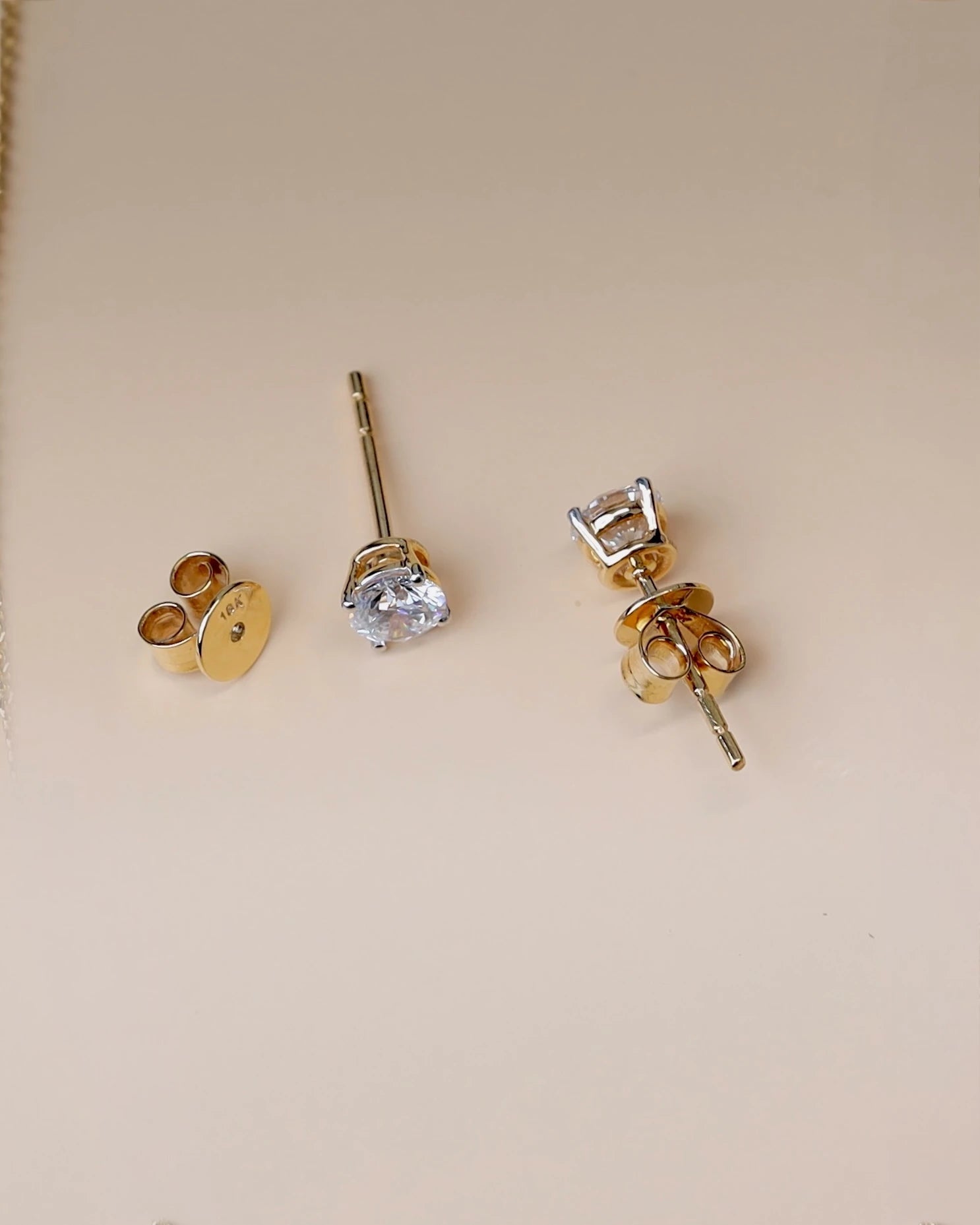 Close up of diamond studs in yellow gold.