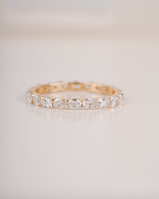 Close up shot of diamond eternity band in yellow gold.