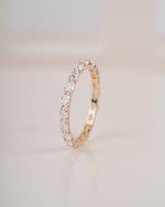 Close up shot of diamond eternity band in yellow gold.