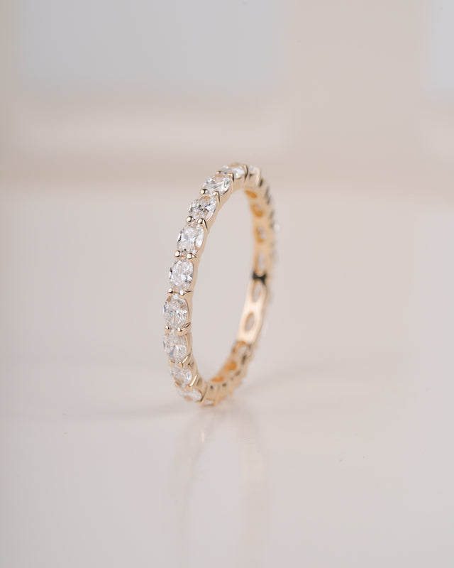 Close up shot of diamond eternity band in yellow gold.