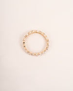 Close up shot of diamond eternity band in yellow gold.
