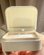 Close up of round diamond engagement ring with pave band.