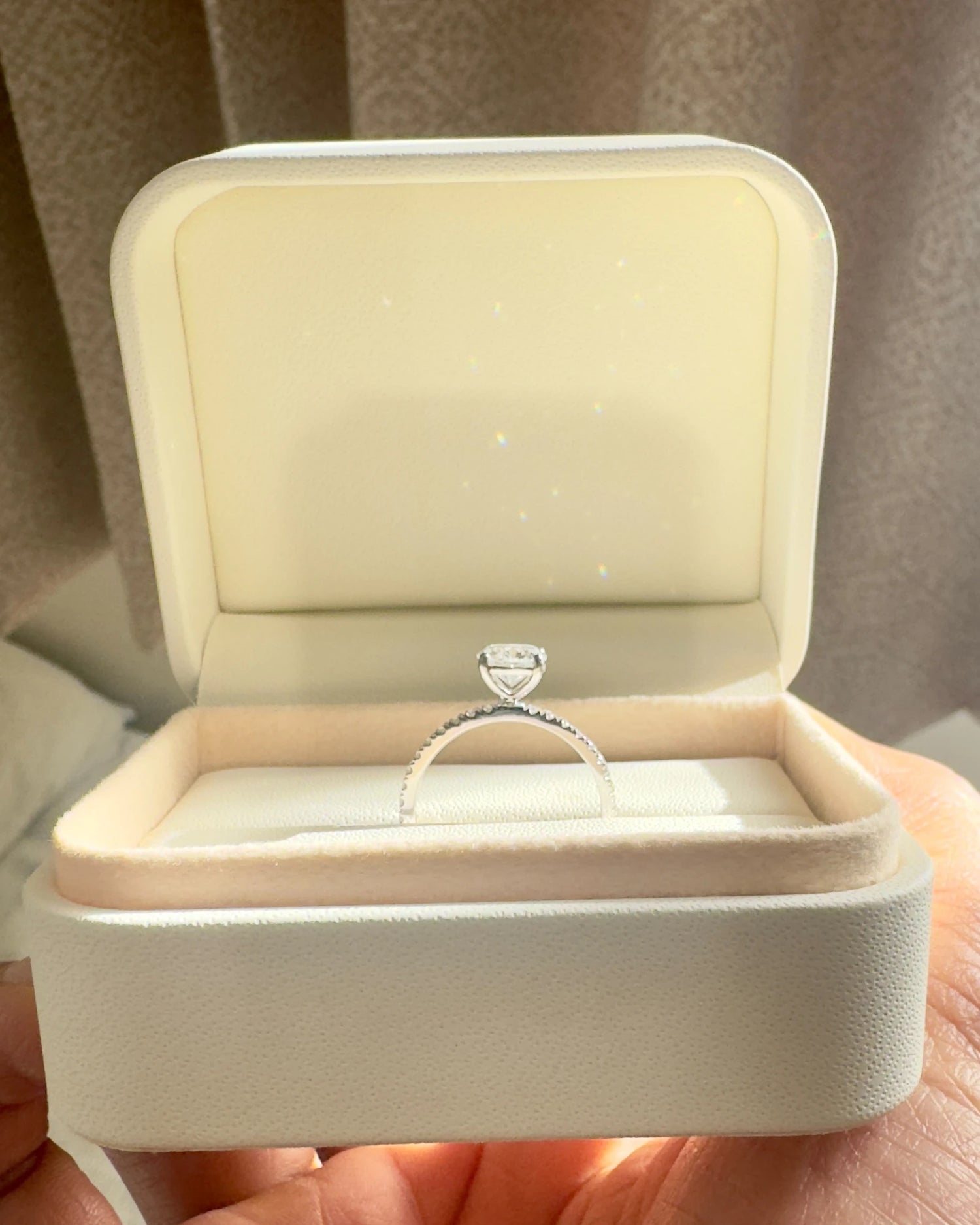 Close up of round diamond engagement ring with pave band.