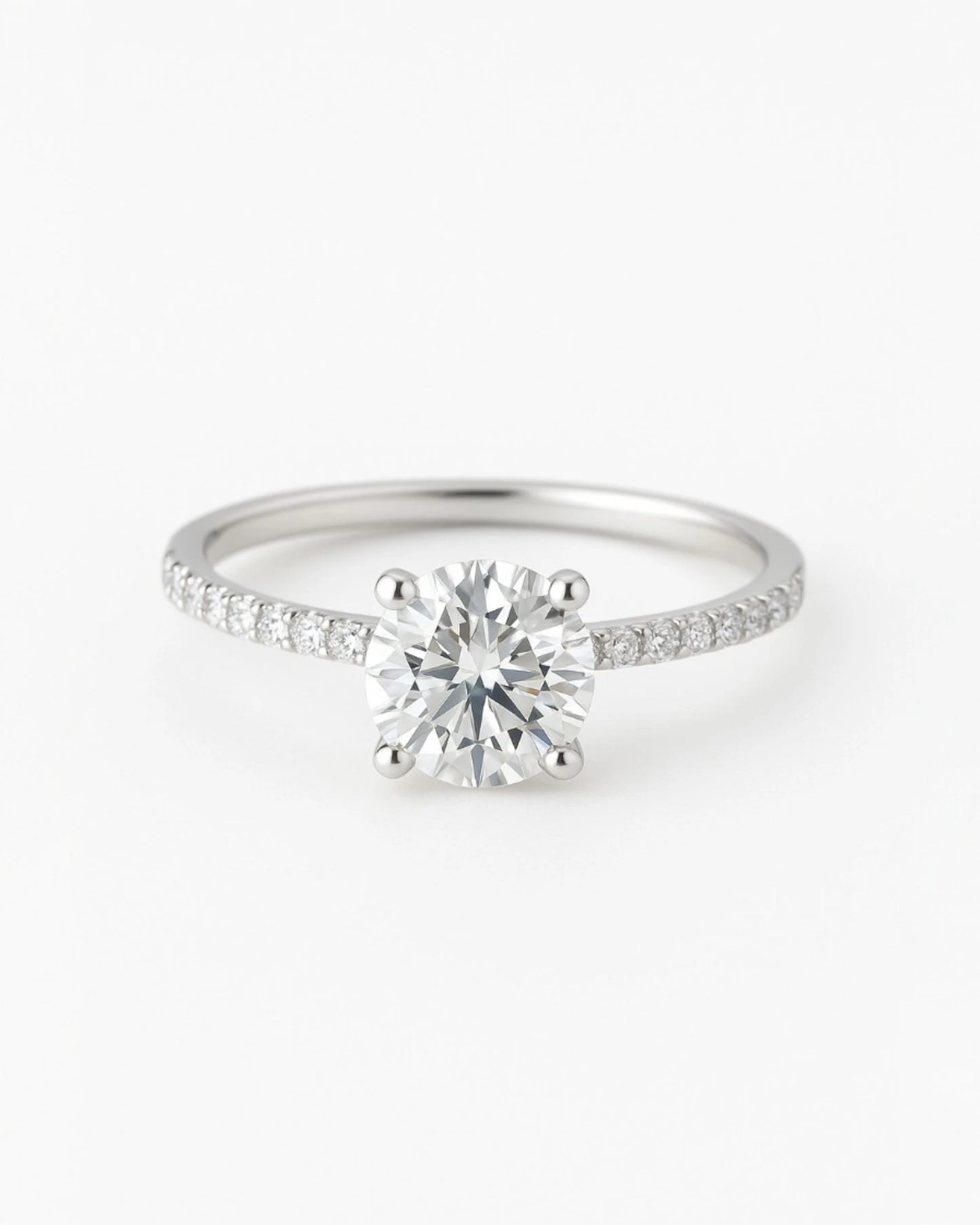 Close up of round diamond engagement ring with pave band.