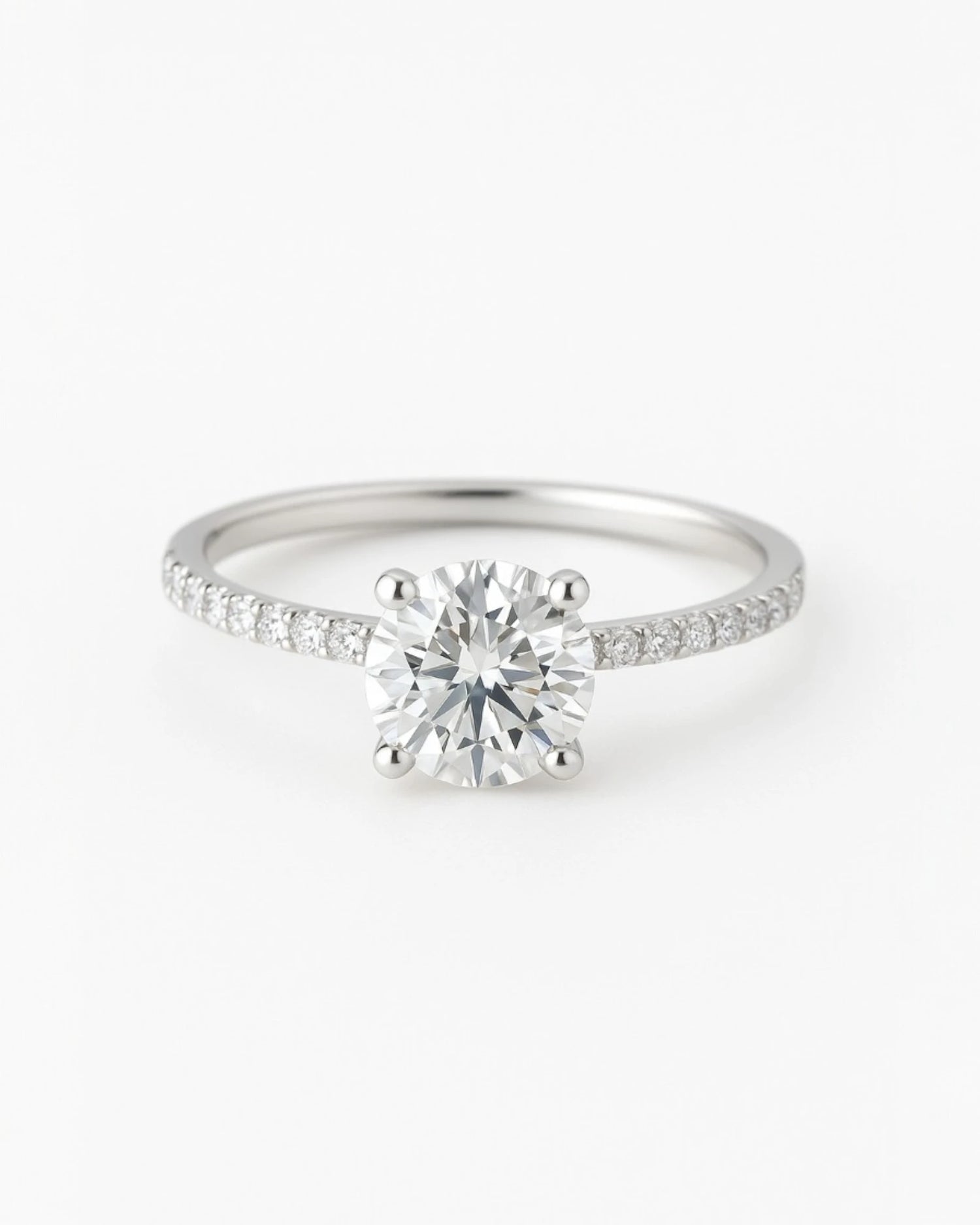 Close up of round diamond engagement ring with pave band.