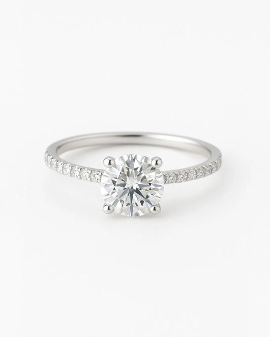 Close up of round diamond engagement ring with pave band.