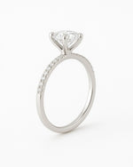 Side view of  round diamond engagement ring with pave band.