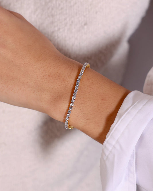 Hand wearing yellow gold tennis diamond bracelet.