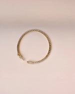 Close up of yellow gold tennis diamond bracelet.