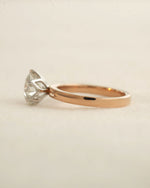 Side view of 2ct round brilliant engagement ring in rose gold with white gold prongs. 
