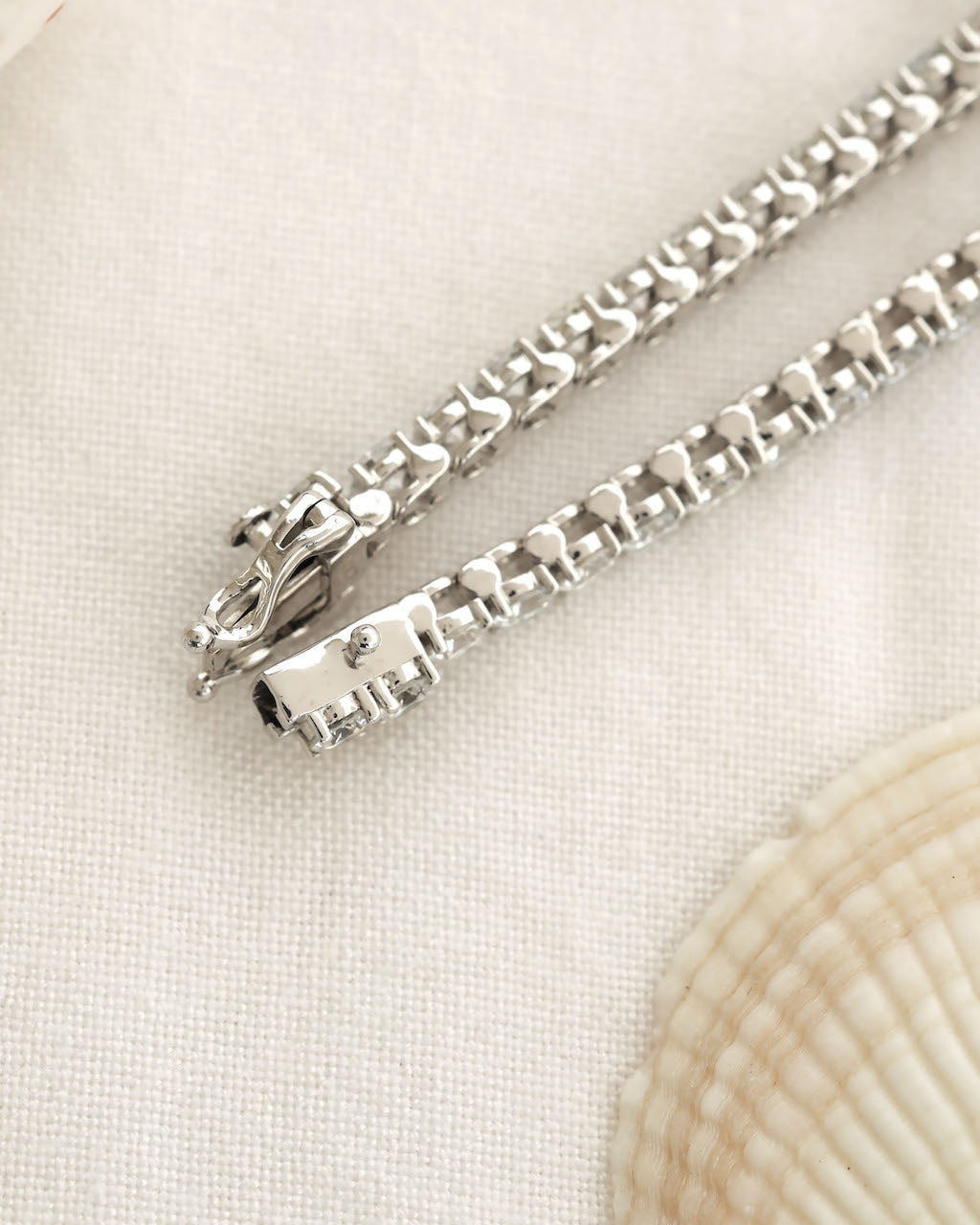 Silver bracelet on a light beige fabric background