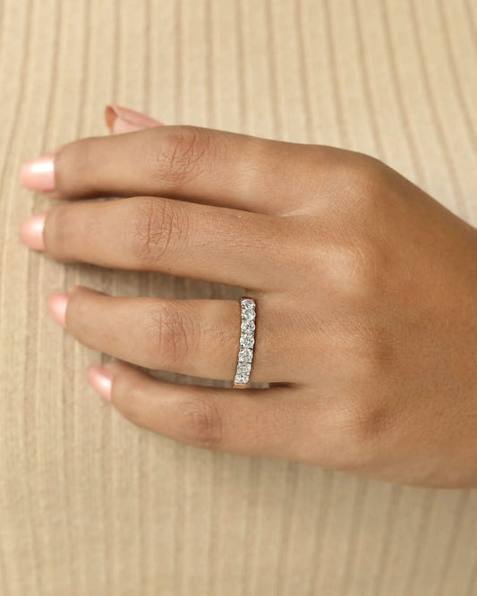 Hand wearing a 7 stone half eternity diamond ring.