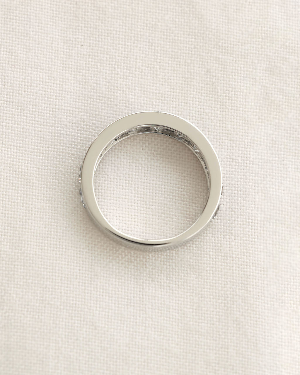 Close up shot of channel set diamond eternity ring in white gold.
