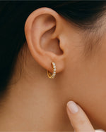  Person wearing classic pave diamond hoop earrings.