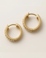  Close up shot of classic pave diamond hoop earrings.