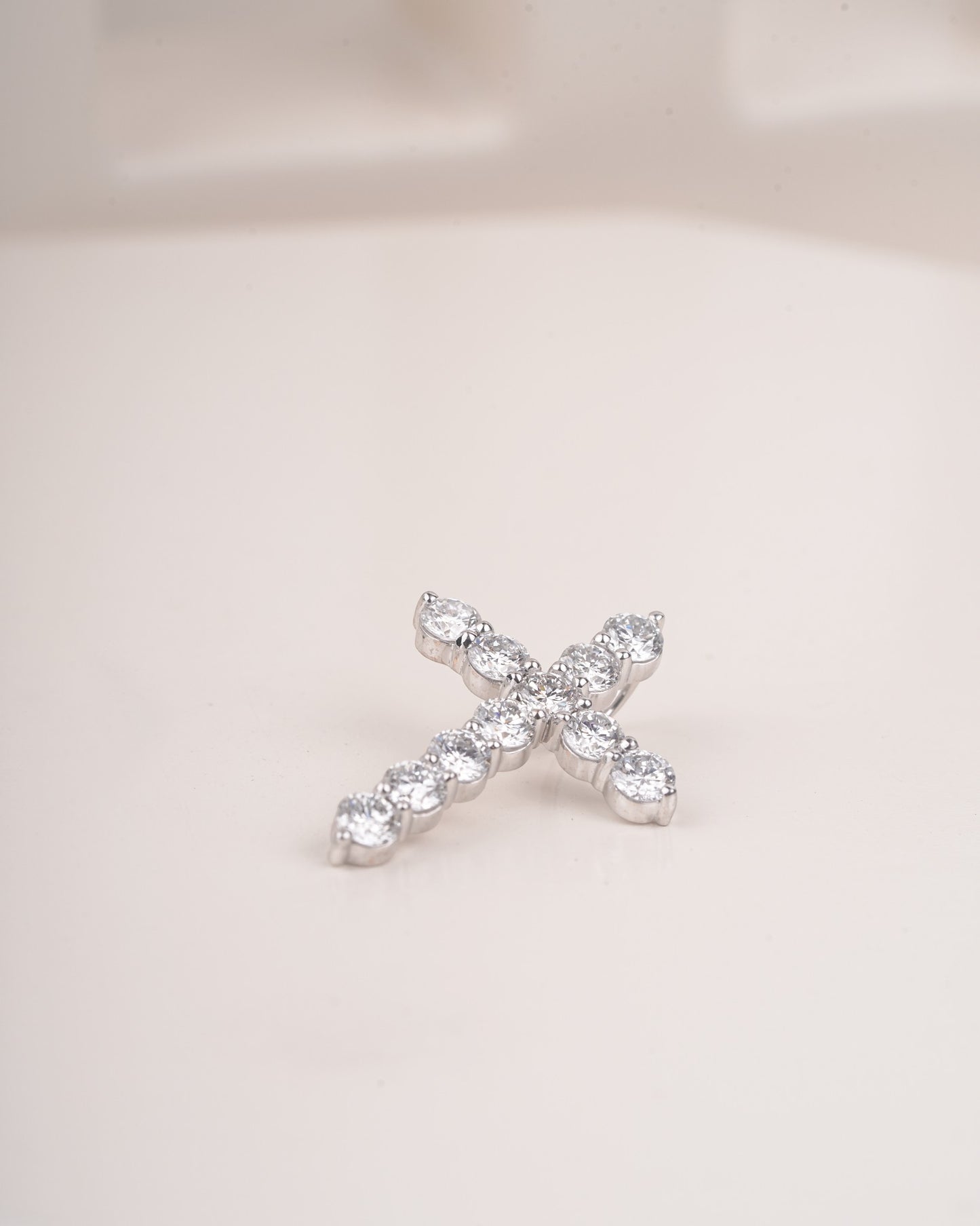 Close up shot of cross diamond pendant in white gold.
