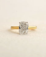 Gold ring with a large diamond on a beige background.