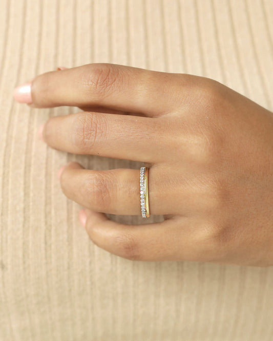 A yellow gold half eternity diamond band worn on a hand.