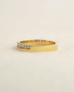 Yellow gold diamond band on a white background.