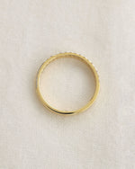 Yellow gold diamond band on a white background.