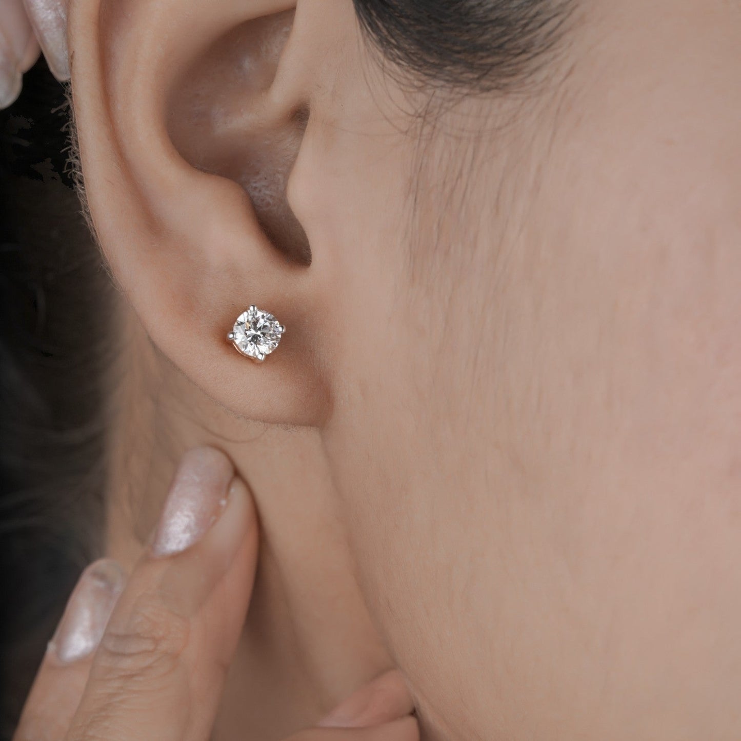 Close up shot of diamond studs earrings in yellow gold.