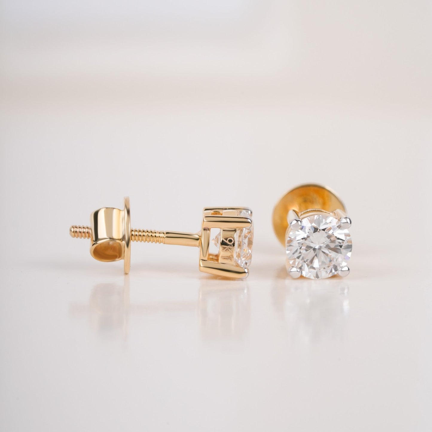 Close up shot of diamond studs earrings in yellow gold.
