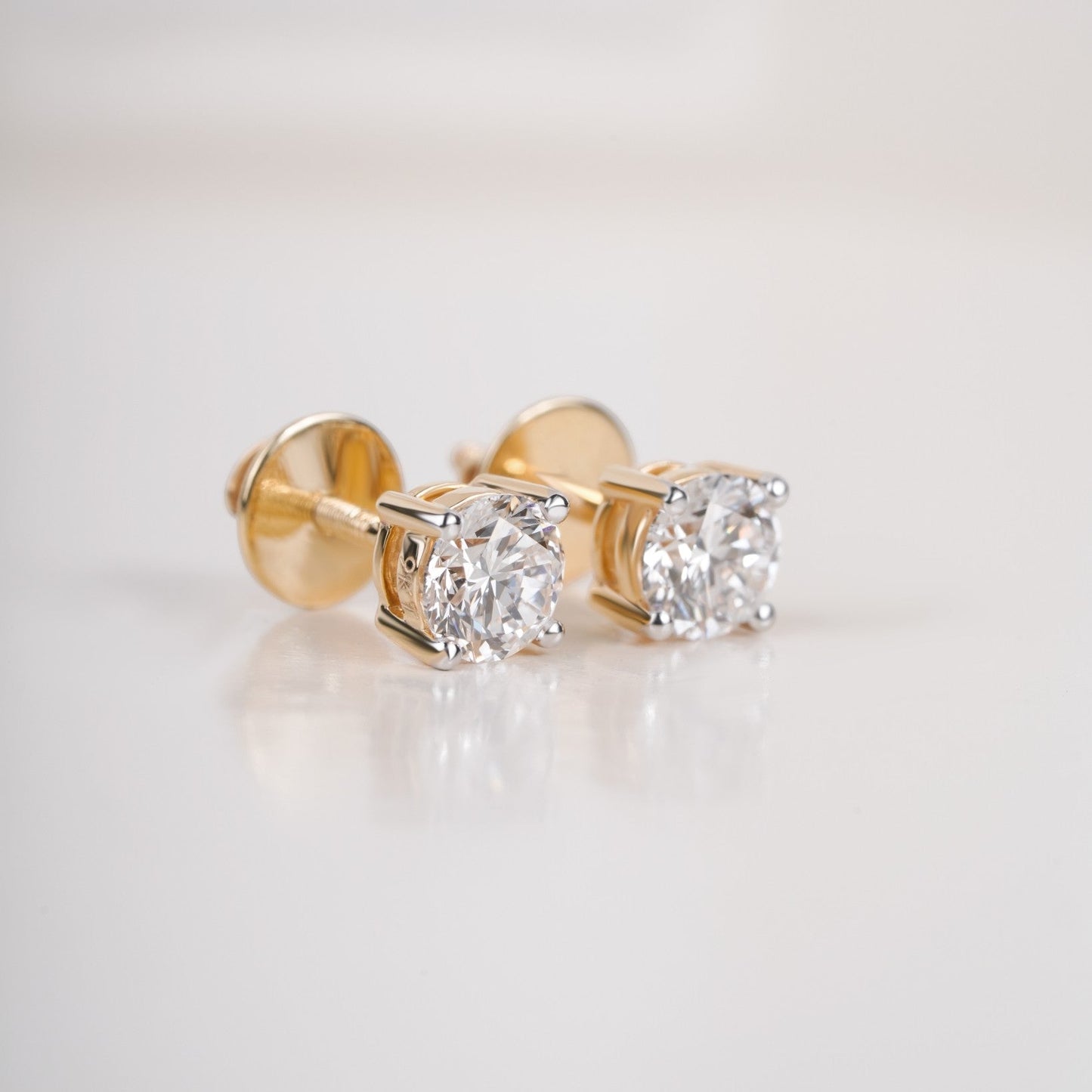 Close up shot of diamond studs earrings  in yellow gold.