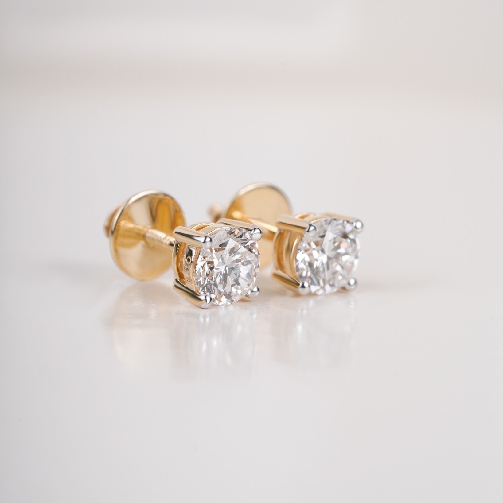 Close up shot of diamond studs earrings  in yellow gold.