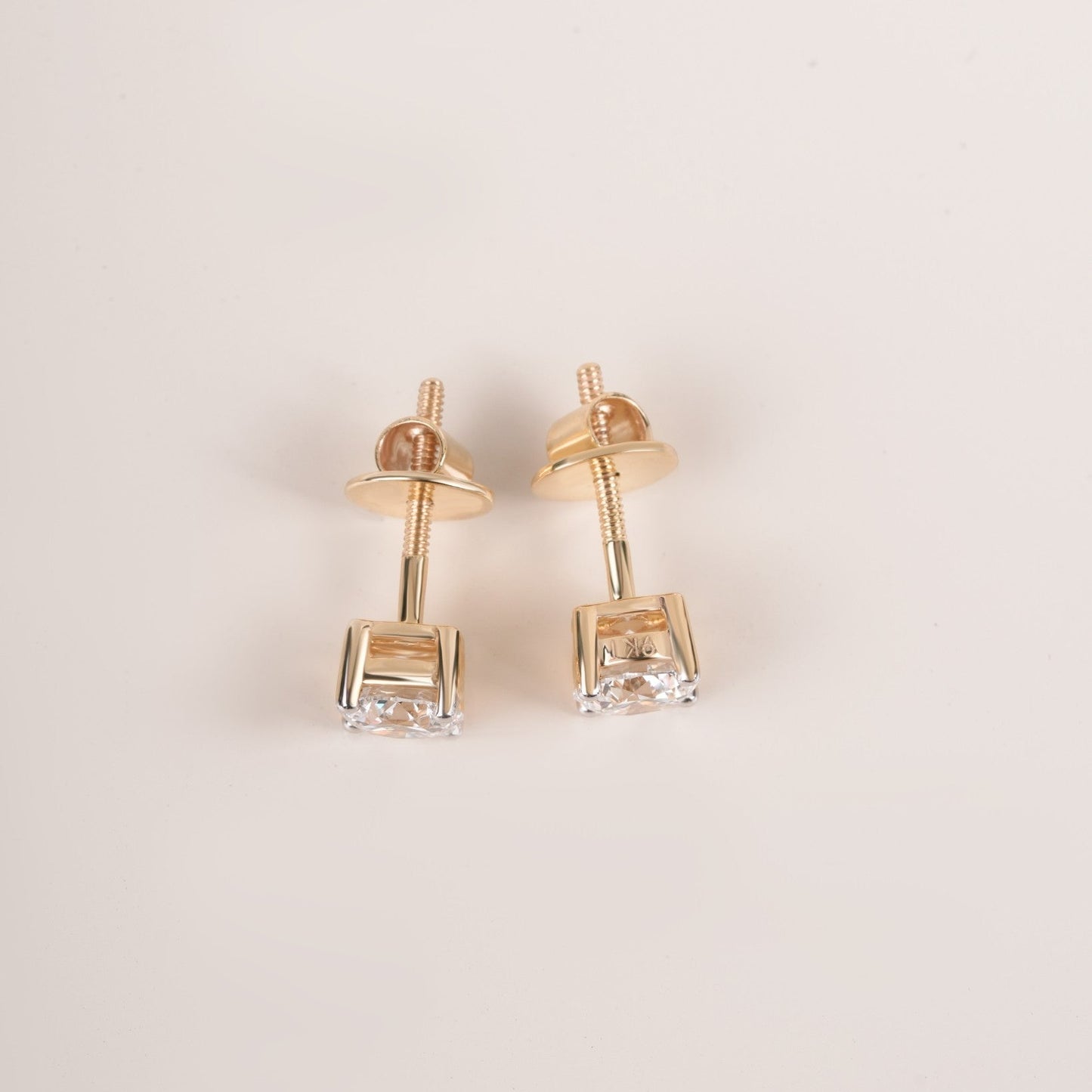 Close up shot of diamond studs earrings in yellow gold.